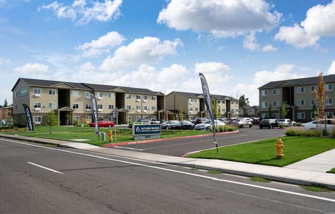 a street with an apartment complex with cars parked in front of it