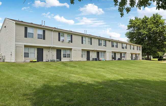 A long building with a green lawn in front.