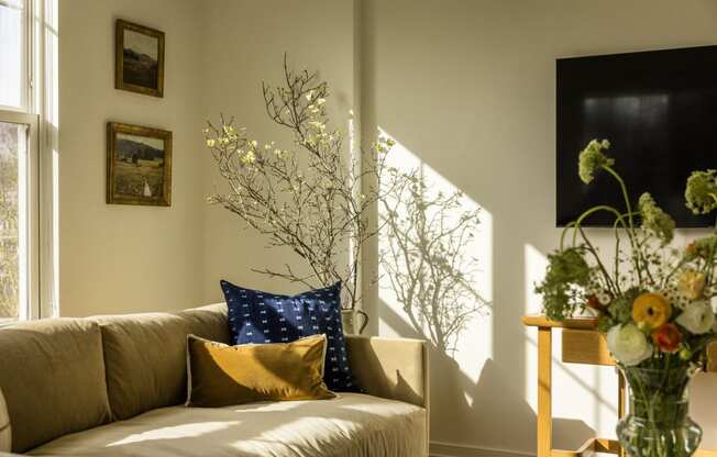a living room with a couch and a vase of flowers