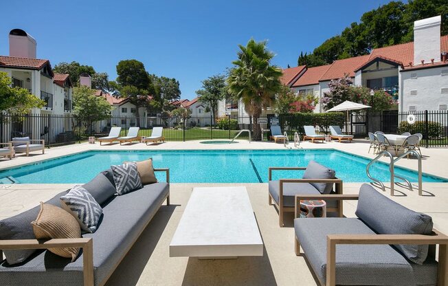 Outdoor Pool With Crystal Clear Water, Lounge Chairs, and Additional Cushioned Seating With a Table at Laurel Creek, Fairfield, 94533
