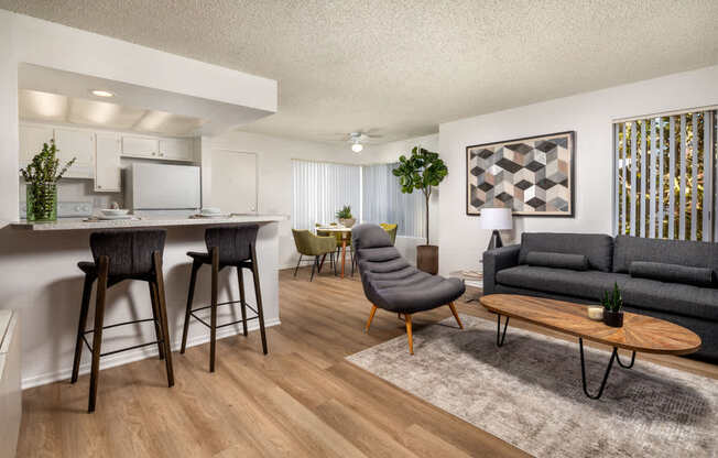 A modern living room with a grey sofa and wooden floors.