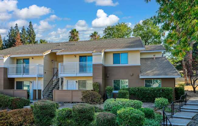 Exterior of Canyon Terrace Apartments with mature landscaping and walkway stairs on the right.