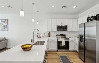 A modern kitchen with white cabinets and stainless steel appliances.