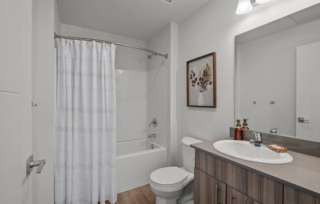 a bathroom with a shower and a sink and a toilet