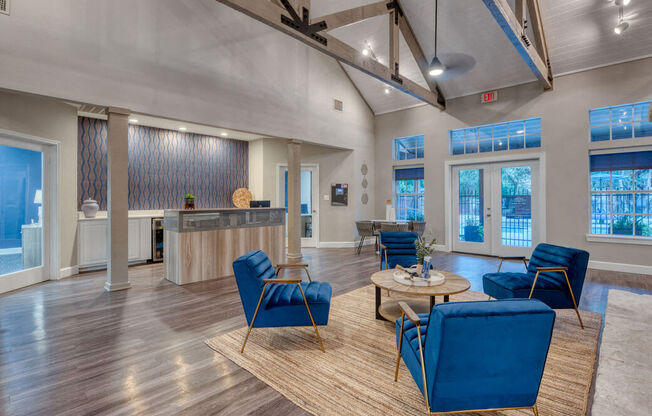 a living room with blue chairs and a table