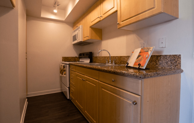 A kitchen with wooden cabinets and a granite countertop.
