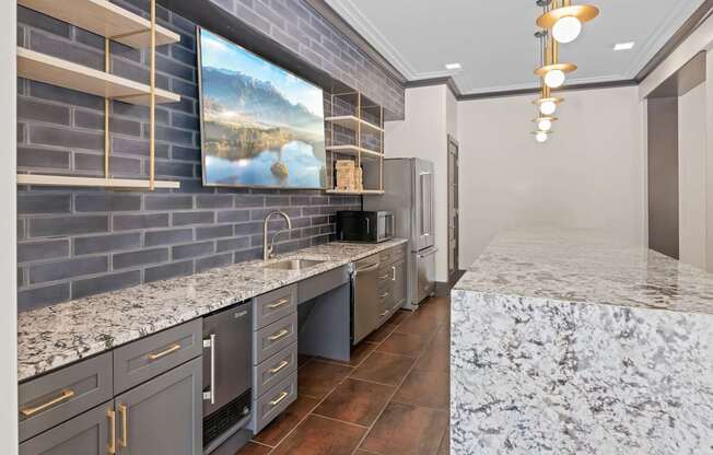 A kitchen with a marble countertop and a painting of a lake on the wall.