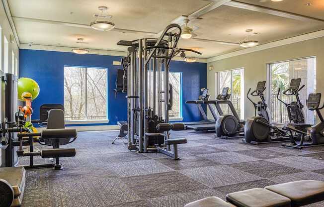 A spacious gym with a variety of equipment including treadmills, weights, and exercise machines.