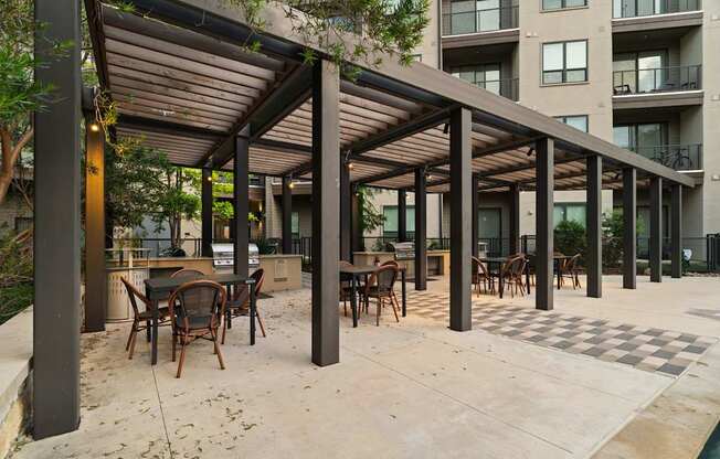 A patio with a table and chairs under a roof.