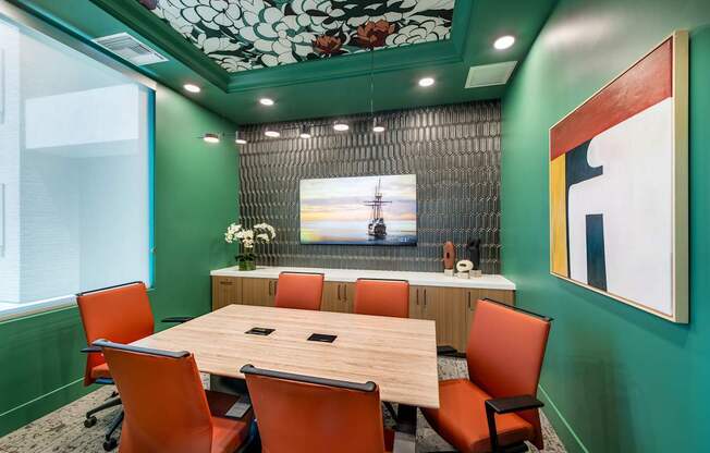 a conference room with a wooden table and orange chairs