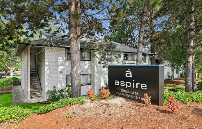 A sign for a place called Aspire is in front of a house.