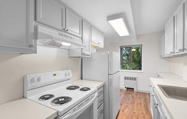 a white kitchen with white appliances and white cabinets