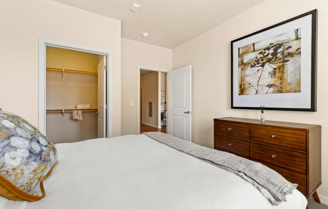 a bedroom with a bed, dresser, and an open closet at Sylvan Uptown,Colorado, Denver