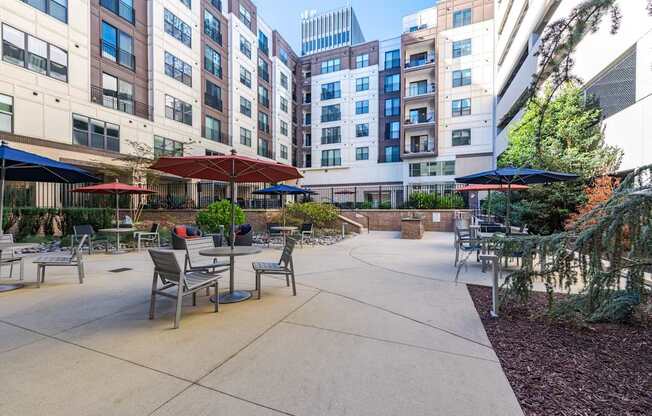 A courtyard with tables and chairs surrounded by buildings.