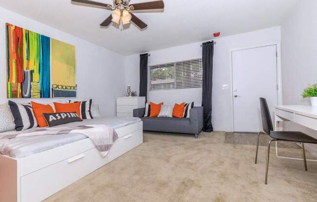 A bedroom with a bed, a chair, and a painting on the wall.