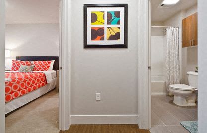 a bedroom with a bed and a toilet in a bathroom