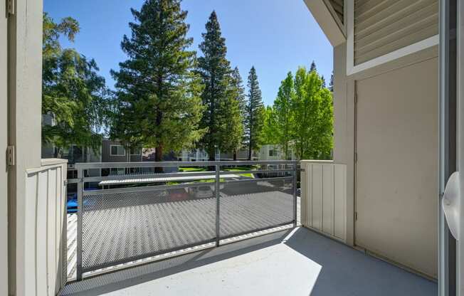 the view of a tennis court from a balcony with a fence at Rush River Apartments, Sacramento