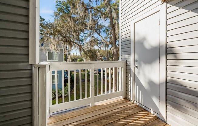 a porch with a white railing and a door