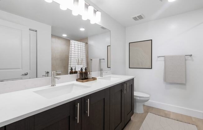a bathroom with a sink and a toilet and a mirror at One Plantation in Plantation, FL 33324