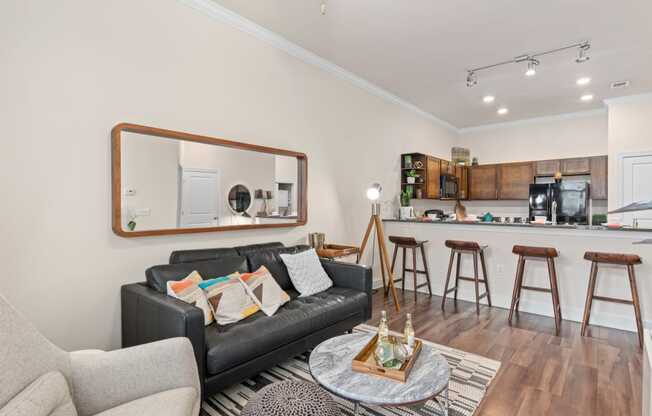 a living room with a couch and a coffee table in front of a kitchen