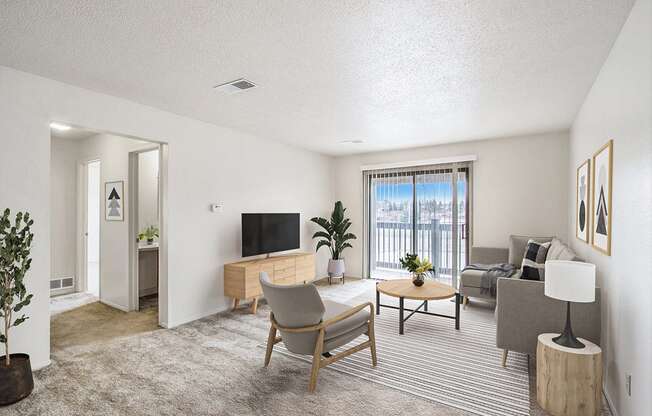 a living room with a couch and a slider to a balcony at Seville Apartments, Kalamazoo, MI, 49009
