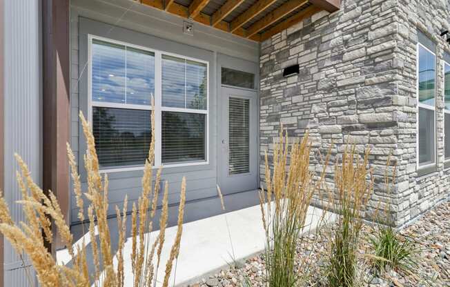 the front porch of a home with stone walls and a wood ceiling at The Depot Raymore, MO 64083