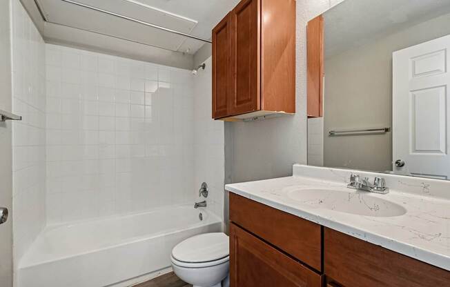 A white bathroom with a toilet, sink, and bathtub.