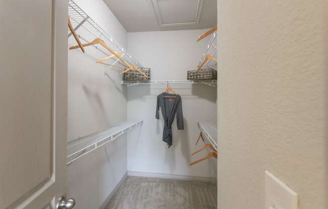 This is a photo of the bedroom walk-in closet in the 826 square foot 1 bedroom , 1 bath apartment at The Brownstones Townhome Apartments in Dallas, TX.