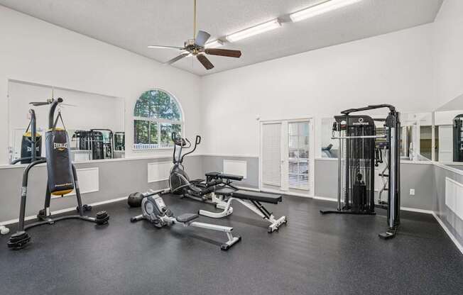 A spacious home gym with a variety of equipment including a treadmill, stationary bike, and weight machines.