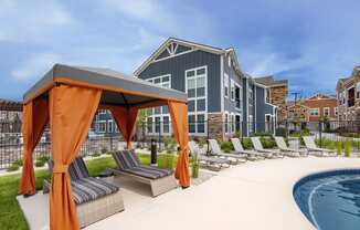 an outdoor pool with lounge chairs and a building in the background at Watermark on Twenty Mile, Colorado 80134
