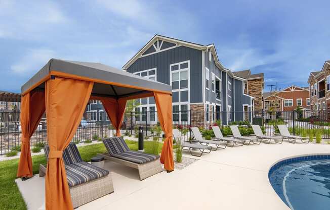 an outdoor pool with lounge chairs and a building in the background at Watermark on Twenty Mile, Colorado 80134