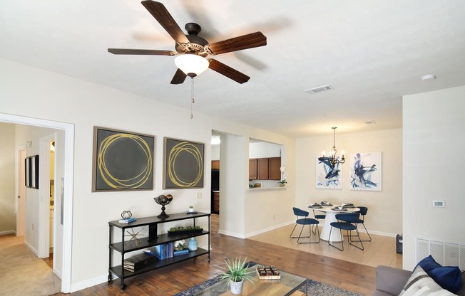 a living room with a ceiling fan and a dining room