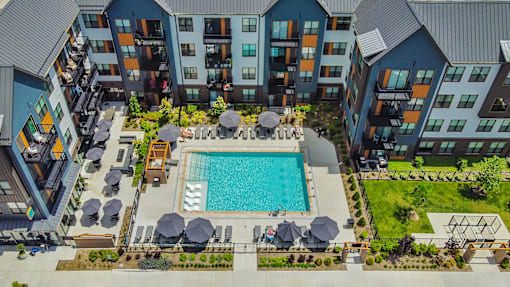 an overhead view of an apartment building with a swimming pool