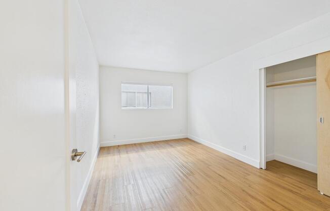 A room with wooden flooring and a window.