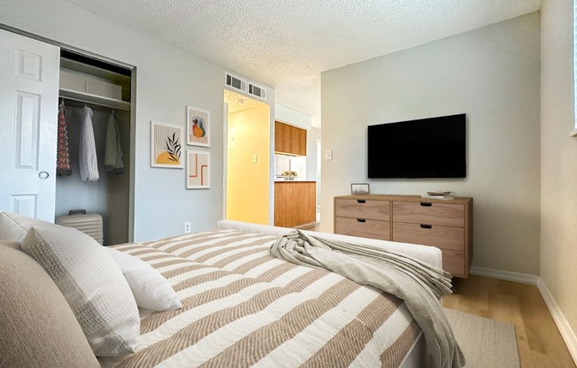 Bedroom with dresser and neutral decor in Gateway Park area apartment.
