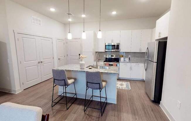 A kitchen with a table and chairs in the middle of the room.