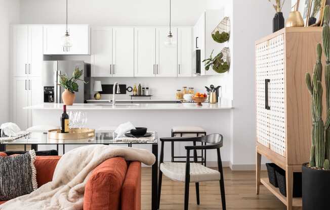 a living room with an orange couch and a kitchen with a table and chairs