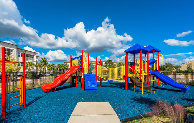 View of Playground, Showing Playground Equipment, Monkey Bars, and Slides at The Marq Highland Park Apartments