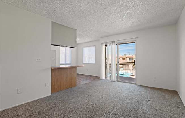 A room with a carpeted floor and a balcony with a railing.