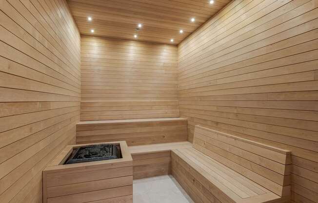 A wooden sauna with benches and a hot tub.