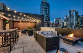 a rooftop patio with a city skyline at night