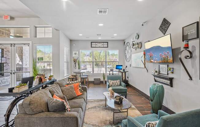 A living room with a grey couch and a green armchair.