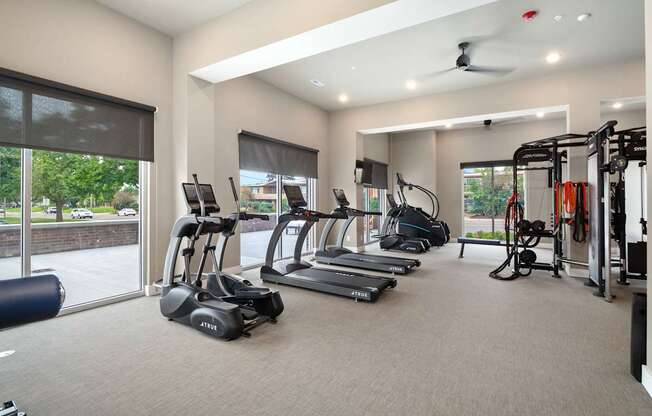 A spacious gym with a variety of equipment including treadmills, elliptical machines, and weight machines.