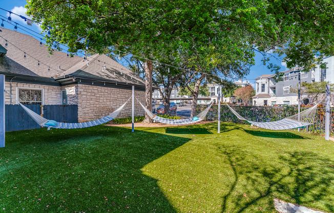 a yard with hammocks in the yard of a house