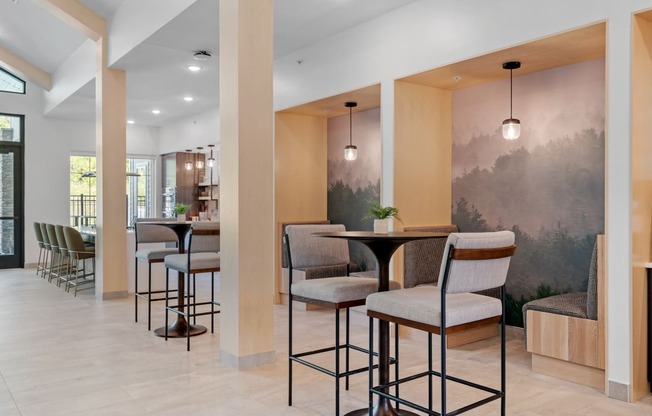 a seating area with tables and chairs in the lobby of a building at The Lodge at Overland, Rochester, Minnesota