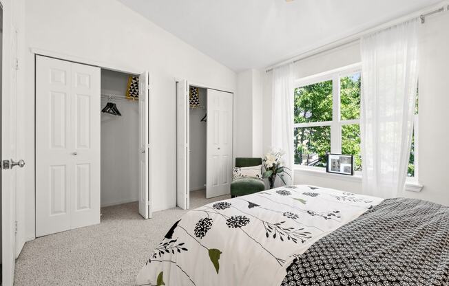 a bedroom with a bed and a chair in front of a window