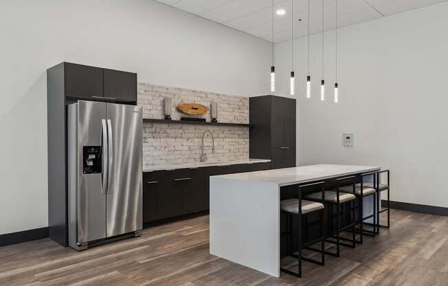 A modern kitchen with a stainless steel refrigerator and a white countertop.