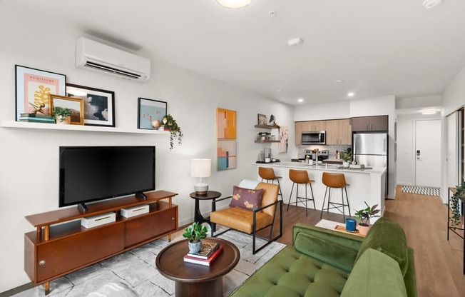 A living room with a green couch and a wooden entertainment center.