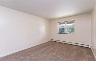 a bedroom with white walls and carpet