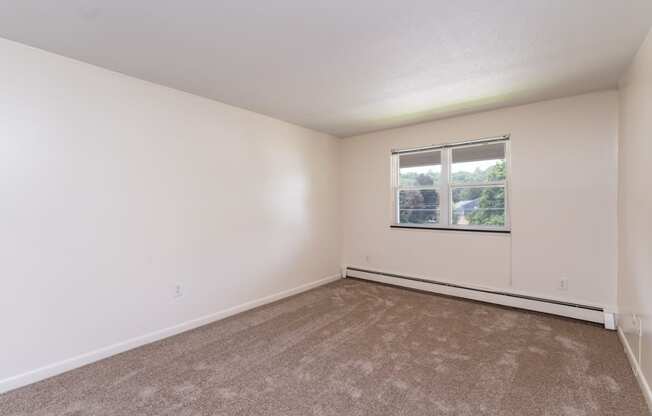 a bedroom with white walls and carpet